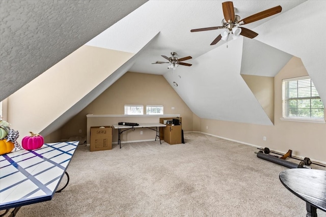 carpeted home office with ceiling fan, plenty of natural light, a textured ceiling, and vaulted ceiling