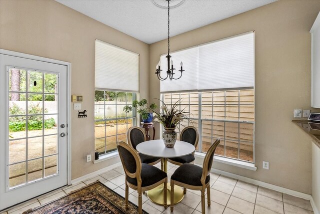 tiled dining room with an inviting chandelier and a textured ceiling