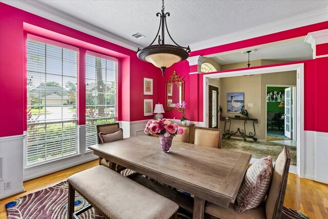 dining area featuring a textured ceiling, a wealth of natural light, and light hardwood / wood-style flooring