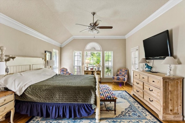 bedroom with crown molding, vaulted ceiling, a textured ceiling, and wood finished floors