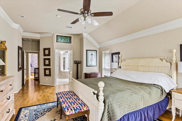 bedroom featuring multiple windows, visible vents, vaulted ceiling, and wood finished floors