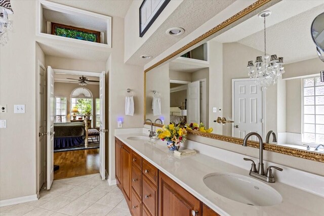 bathroom featuring a textured ceiling, vanity, an inviting chandelier, hardwood / wood-style flooring, and lofted ceiling