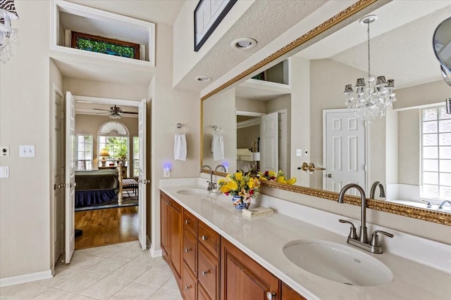 ensuite bathroom with ensuite bathroom, double vanity, tile patterned flooring, and a sink