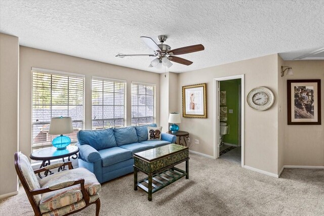 living room with ceiling fan, light carpet, and a textured ceiling