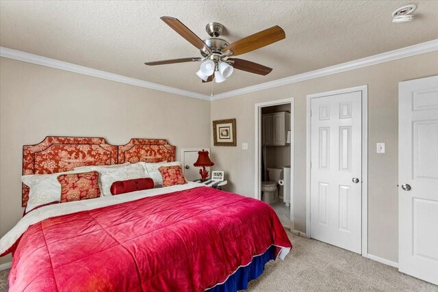 bedroom featuring a textured ceiling, ensuite bath, light colored carpet, ceiling fan, and ornamental molding