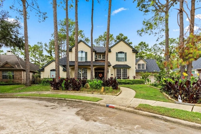 traditional-style house featuring a front yard and brick siding