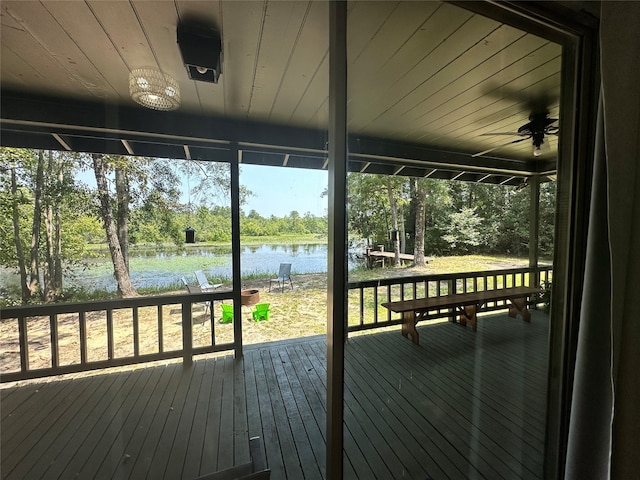 wooden deck with ceiling fan and a water view