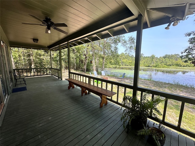 wooden deck with ceiling fan and a water view