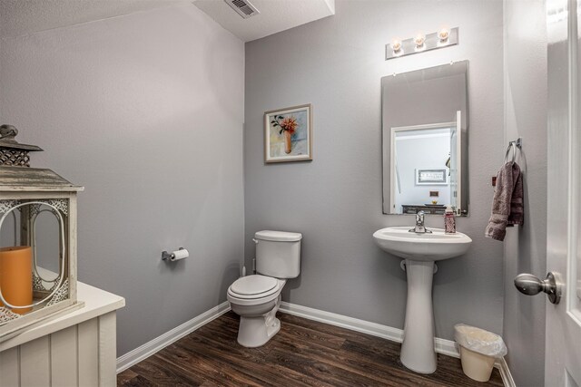 bathroom with toilet and wood-type flooring