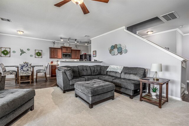 living room with ornamental molding, rail lighting, hardwood / wood-style flooring, and ceiling fan