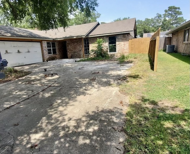 ranch-style house with driveway, central air condition unit, fence, a front lawn, and a garage