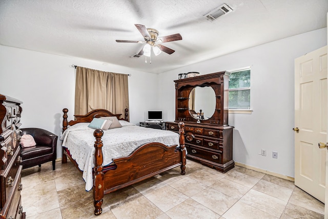 bedroom with a textured ceiling, light tile patterned floors, and ceiling fan