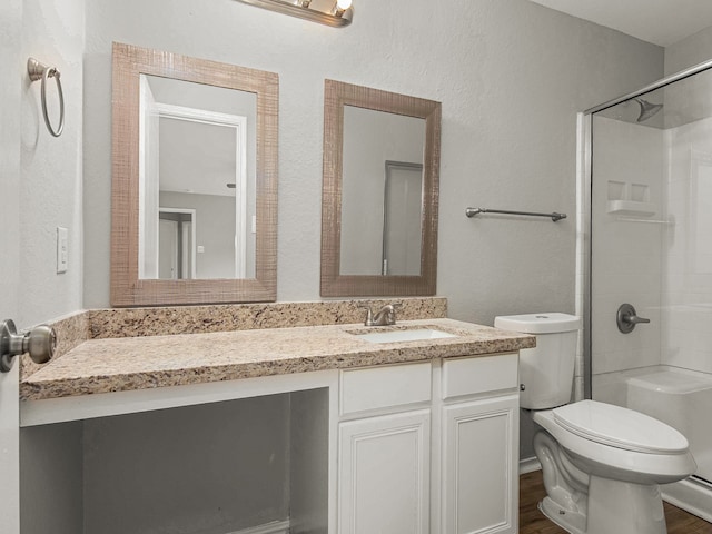 bathroom featuring vanity, toilet, walk in shower, and hardwood / wood-style floors