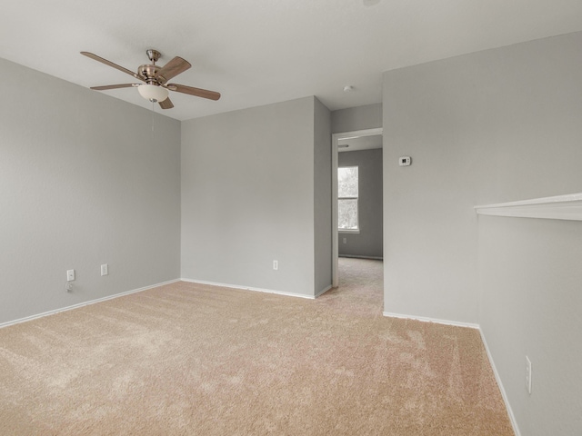 carpeted spare room featuring ceiling fan