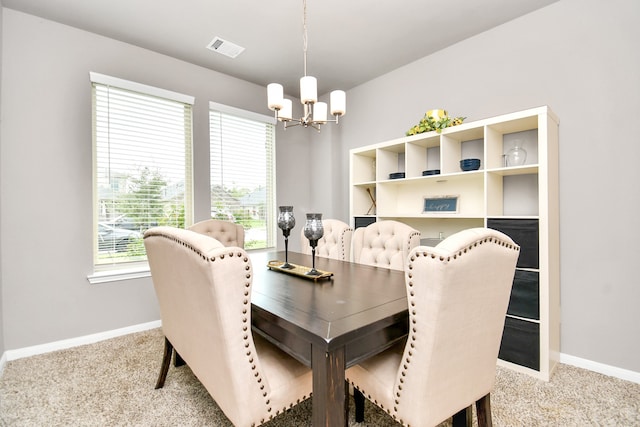 carpeted dining area with a chandelier