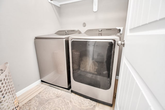 laundry area with light tile patterned floors and washing machine and clothes dryer