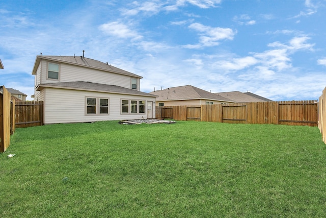 rear view of property featuring a lawn