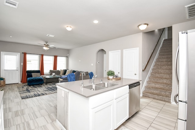 kitchen featuring white refrigerator, sink, an island with sink, dishwasher, and ceiling fan