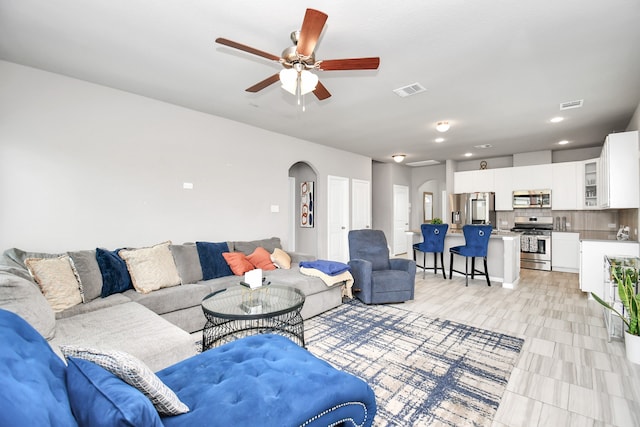 tiled living room with ceiling fan