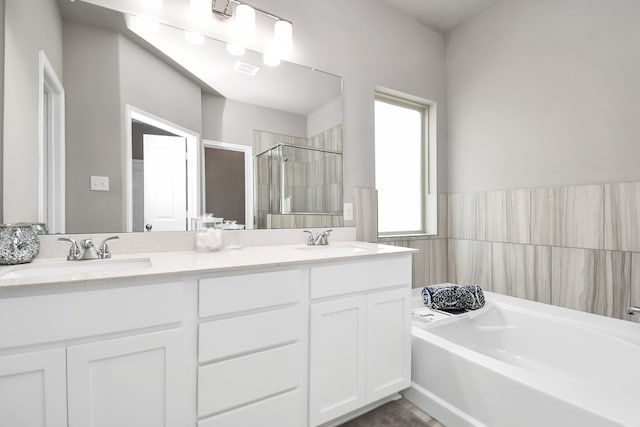 bathroom with shower with separate bathtub and double sink vanity