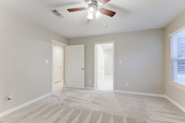 carpeted empty room with a wealth of natural light and ceiling fan