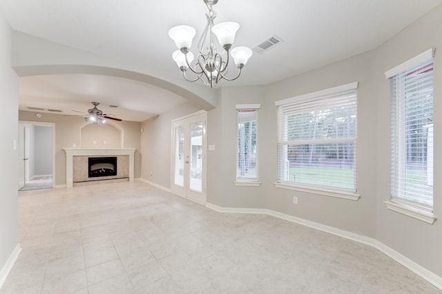 unfurnished living room with a fireplace, ceiling fan with notable chandelier, and light tile patterned floors