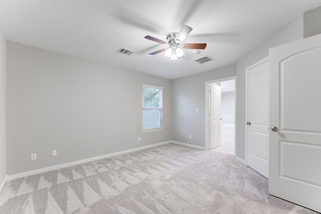 carpeted empty room featuring a textured ceiling and ceiling fan