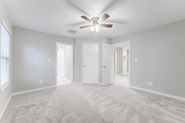 unfurnished bedroom with ceiling fan and light colored carpet