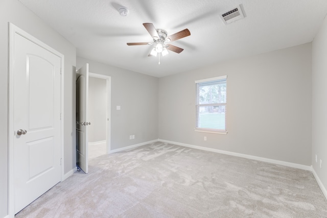 unfurnished bedroom with carpet flooring, a textured ceiling, and ceiling fan