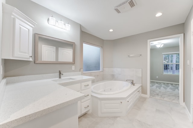 bathroom featuring tile patterned flooring, a bath, and vanity