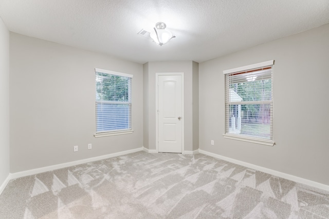 unfurnished room with a textured ceiling and carpet flooring