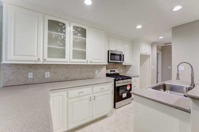 kitchen with light tile patterned flooring, stainless steel appliances, tasteful backsplash, and sink