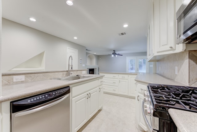 kitchen featuring light tile patterned flooring, ceiling fan, tasteful backsplash, stainless steel appliances, and sink