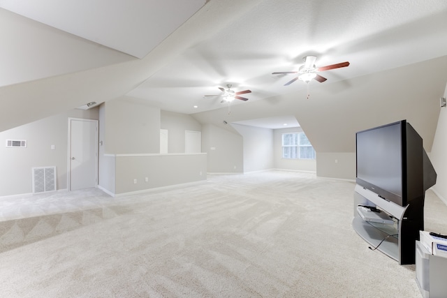 additional living space with light carpet, ceiling fan, vaulted ceiling, and a textured ceiling