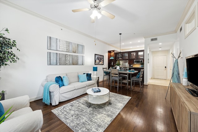 living room featuring ornamental molding, dark hardwood / wood-style flooring, and ceiling fan