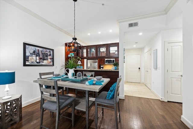 dining room with ornamental molding and wood-type flooring