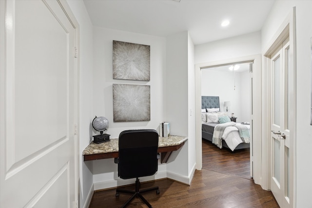 office area with built in desk and dark wood-type flooring