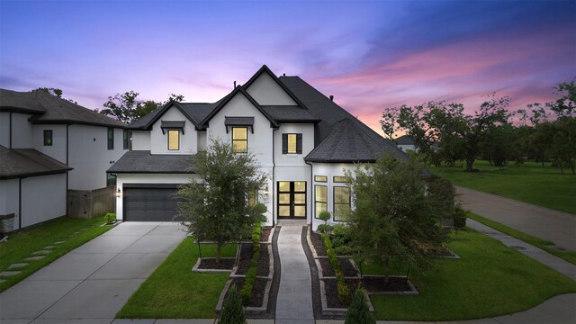 view of front of property with a garage and a yard