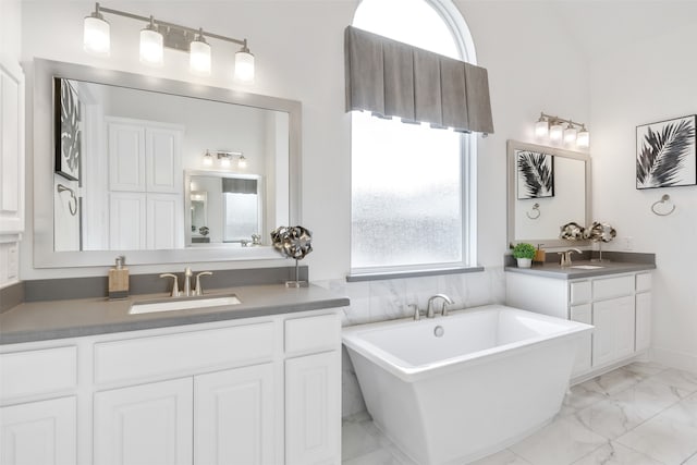 bathroom with a tub to relax in, tile patterned flooring, and dual bowl vanity