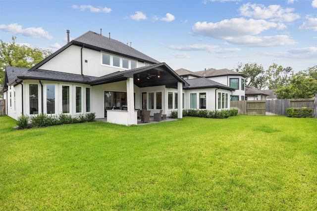 rear view of house featuring a patio, ceiling fan, and a lawn