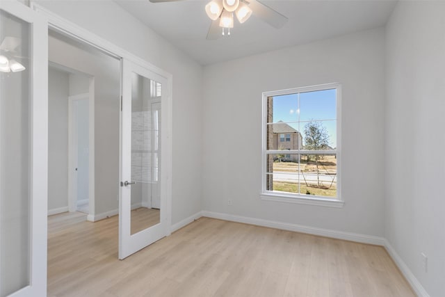 spare room featuring ceiling fan, plenty of natural light, light wood-type flooring, and french doors