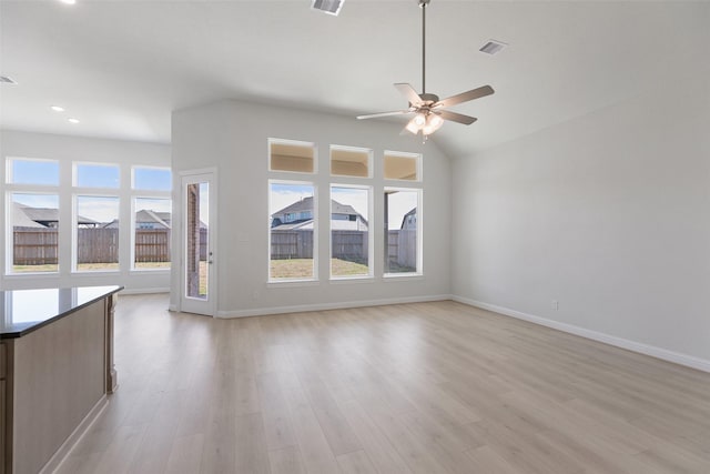 unfurnished living room featuring ceiling fan, vaulted ceiling, and light wood-type flooring