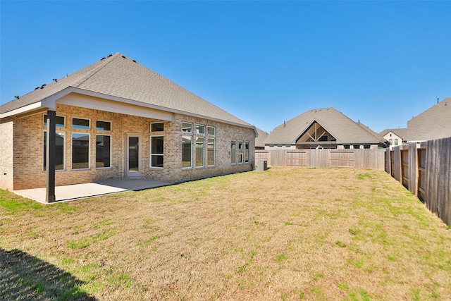 back of house featuring a lawn and a patio