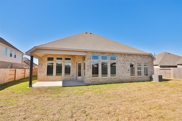 rear view of house with a yard, a patio, and central air condition unit