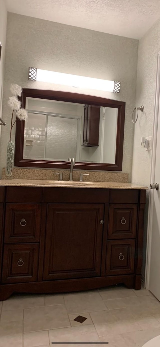 411 Sailfish St, Jones Creek, TX 77541 - bathroom with vanity, a textured ceiling, a textured wall, and tile patterned floors