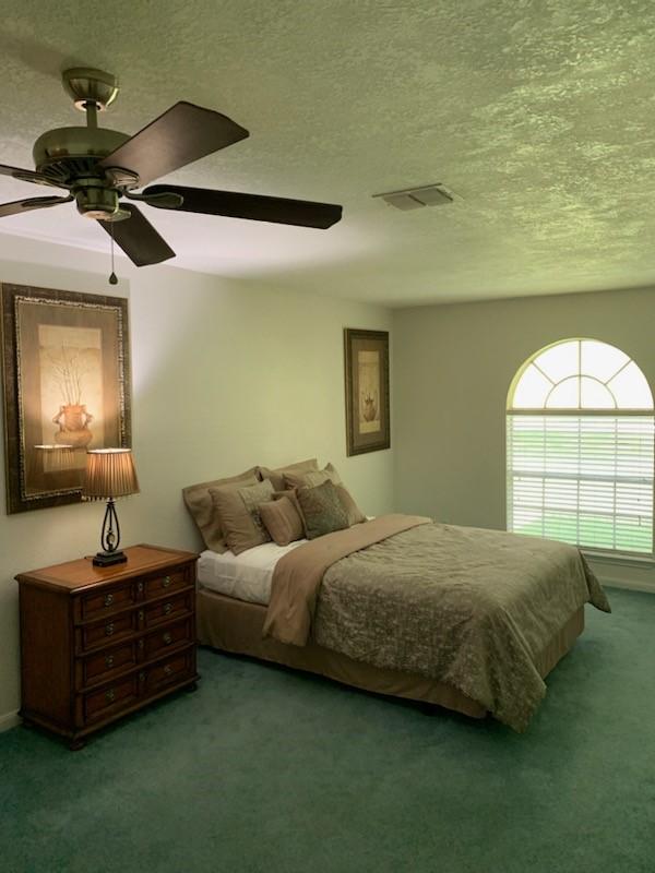 411 Sailfish St, Jones Creek, TX 77541 - carpeted bedroom featuring a textured ceiling and ceiling fan