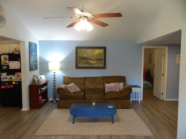 living room featuring ceiling fan, hardwood / wood-style flooring, and lofted ceiling