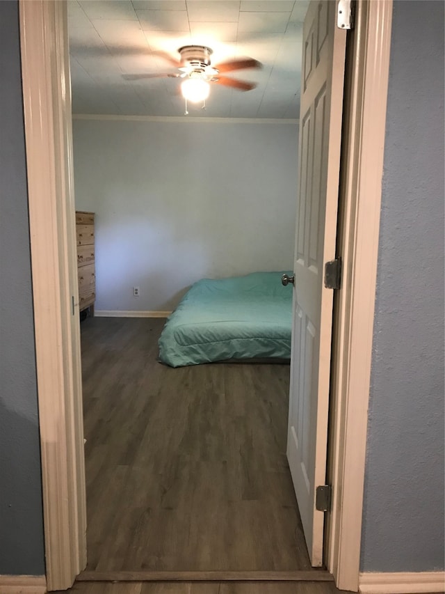 bedroom featuring ceiling fan, dark wood-type flooring, and crown molding