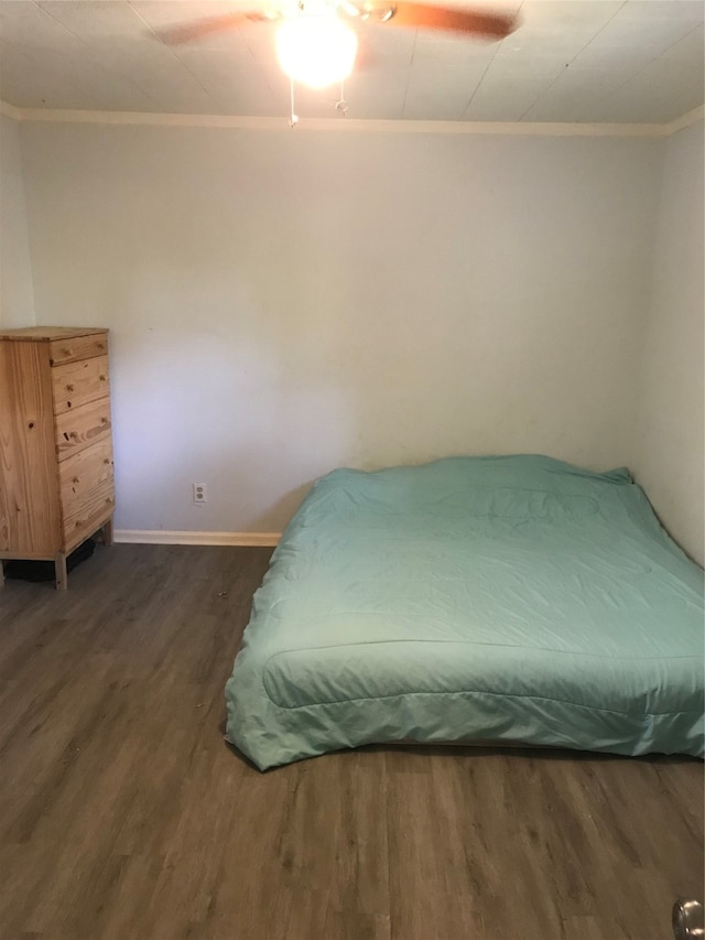 bedroom featuring ornamental molding, ceiling fan, and dark hardwood / wood-style flooring