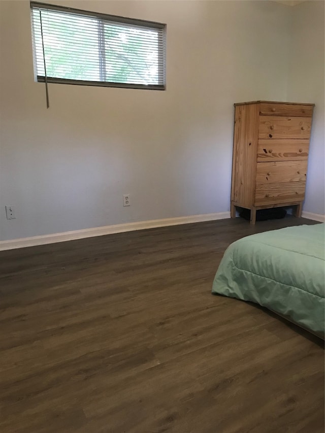 bedroom featuring dark wood-type flooring and multiple windows